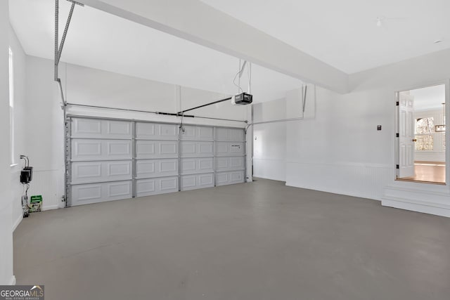 garage featuring wainscoting and a garage door opener