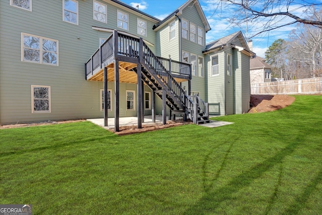 back of house with a patio, fence, a wooden deck, a yard, and stairs