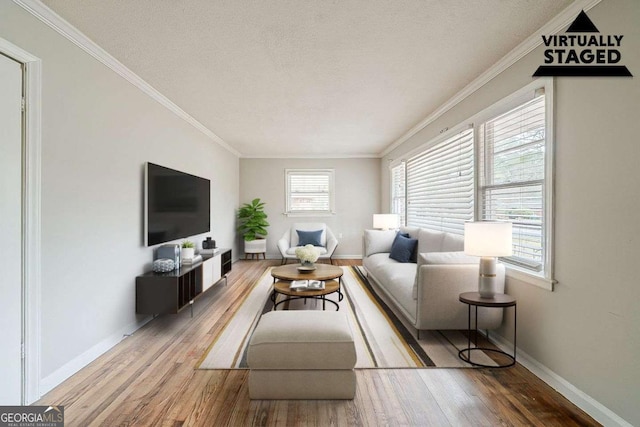 living area featuring a textured ceiling, wood finished floors, baseboards, and ornamental molding