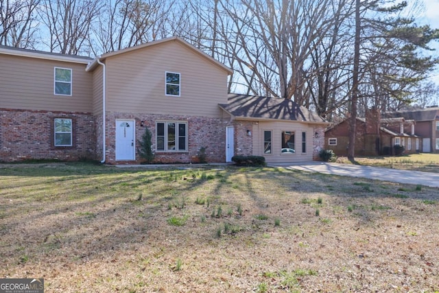 traditional-style house featuring brick siding and a front lawn