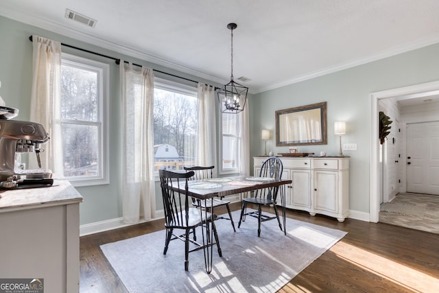 dining space featuring dark wood finished floors, visible vents, a healthy amount of sunlight, and ornamental molding