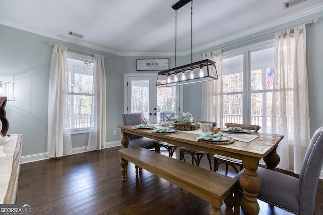 dining room with visible vents, wood finished floors, baseboards, and ornamental molding