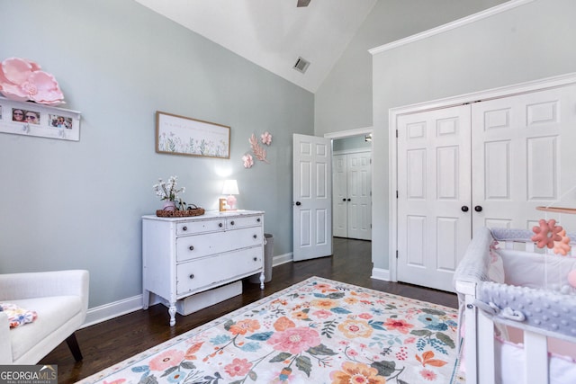 bedroom featuring baseboards, visible vents, high vaulted ceiling, dark wood-type flooring, and a closet