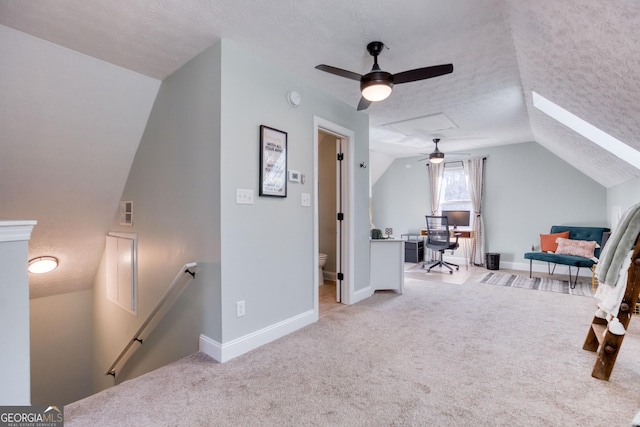 interior space featuring lofted ceiling, baseboards, carpet floors, and a textured ceiling