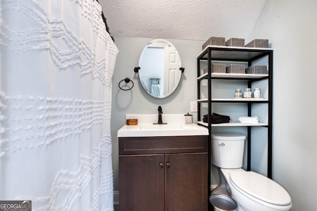 full bathroom with toilet, a textured ceiling, and vanity