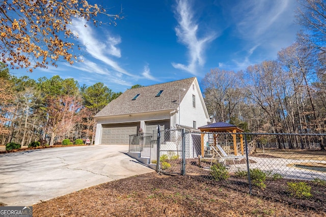 view of side of property with a gate, a shingled roof, and fence