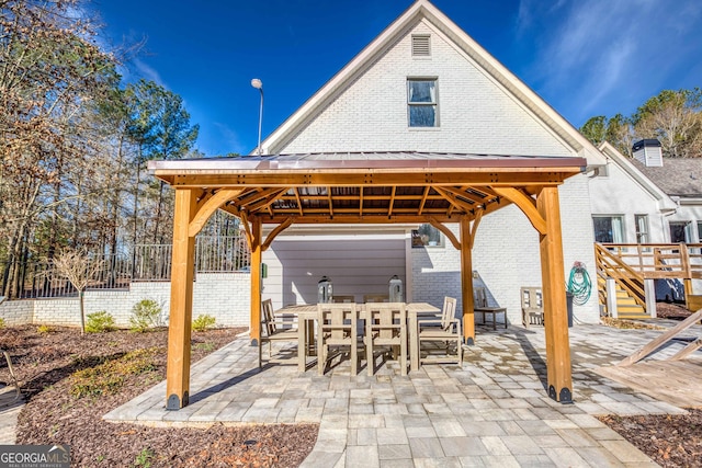 view of patio with a gazebo, outdoor dining space, and fence