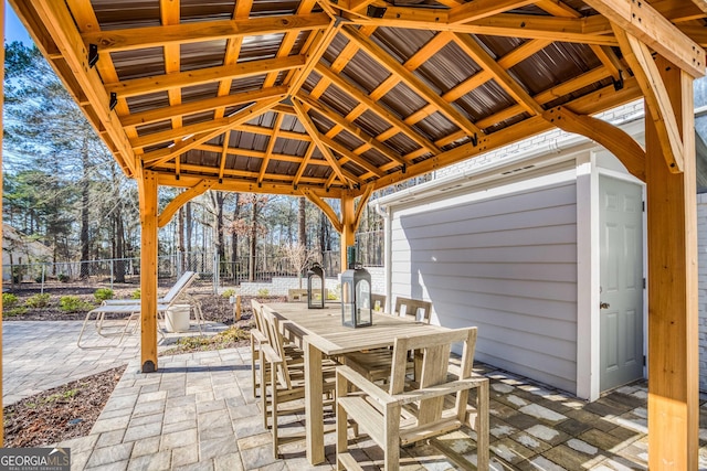 view of patio / terrace with a gazebo, outdoor dining space, and fence