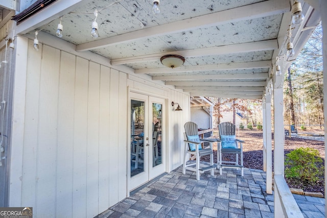 view of patio with french doors and fence