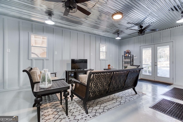 living area featuring a wealth of natural light, french doors, finished concrete flooring, and a ceiling fan