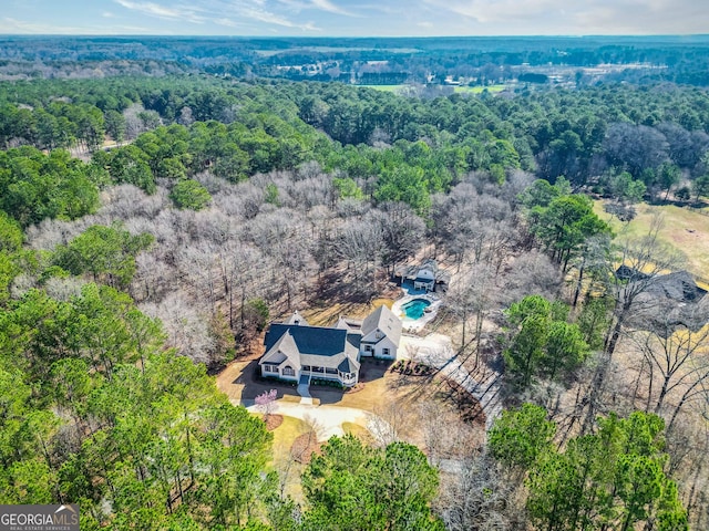 drone / aerial view with a wooded view