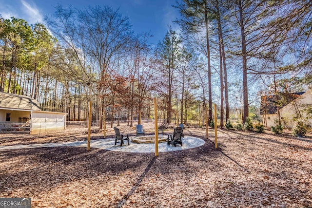 view of yard with a patio, a fire pit, and fence