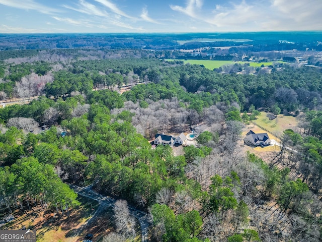 birds eye view of property featuring a view of trees