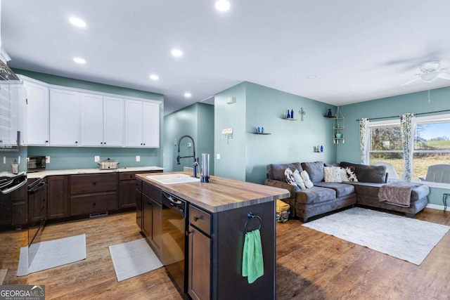 kitchen featuring light wood-style flooring, a sink, open floor plan, white cabinetry, and dishwasher