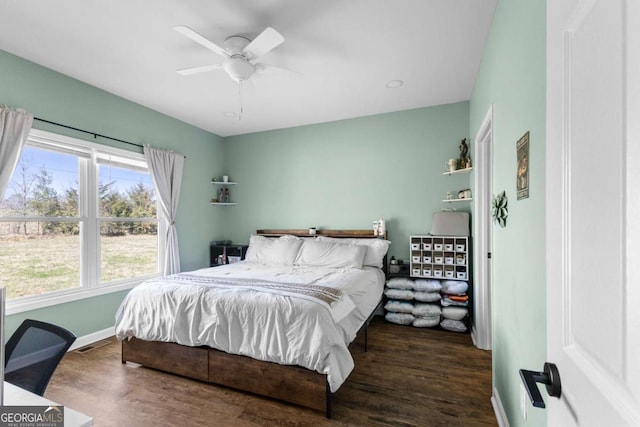 bedroom featuring visible vents, baseboards, wood finished floors, and a ceiling fan