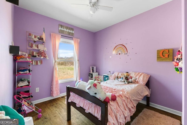 bedroom with a ceiling fan, baseboards, and wood finished floors