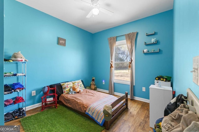 bedroom featuring a ceiling fan, wood finished floors, and baseboards