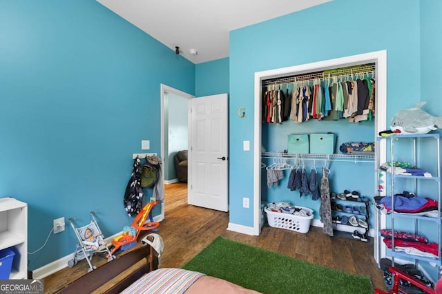 bedroom with a closet, baseboards, and wood finished floors