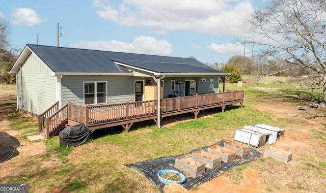 view of front facade featuring metal roof, a deck, and a front lawn