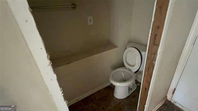 bathroom with toilet and baseboards