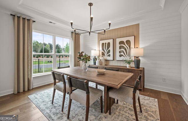 dining area with light wood finished floors, visible vents, crown molding, baseboards, and a notable chandelier