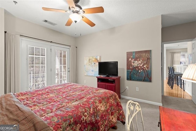 carpeted bedroom featuring visible vents, baseboards, a textured ceiling, a ceiling fan, and access to outside