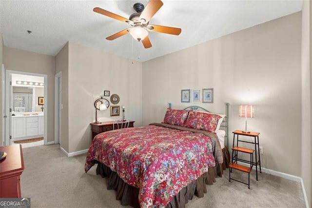 carpeted bedroom featuring connected bathroom and baseboards