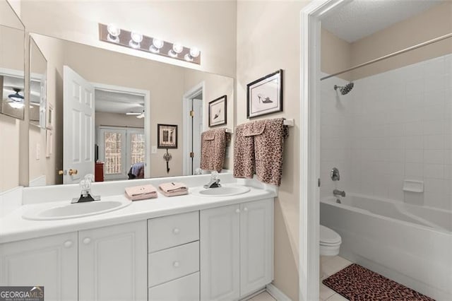 ensuite bathroom featuring ensuite bath, double vanity, a ceiling fan, and a sink