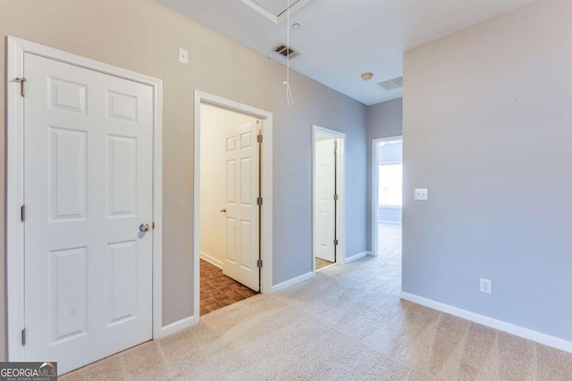 interior space with visible vents, baseboards, carpet, and attic access