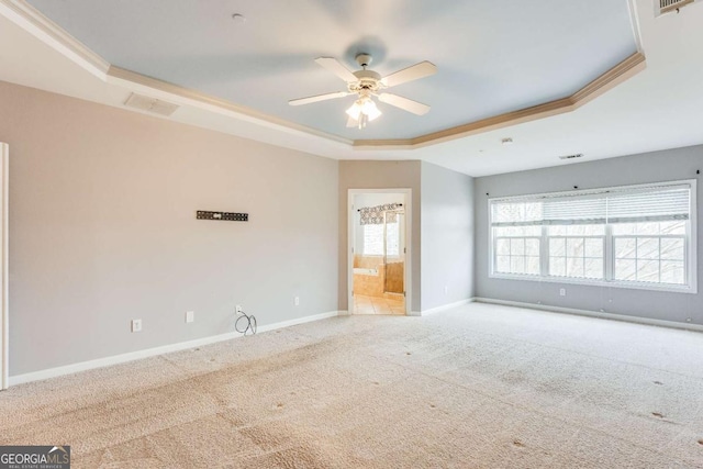 unfurnished room with a tray ceiling, baseboards, visible vents, and carpet flooring