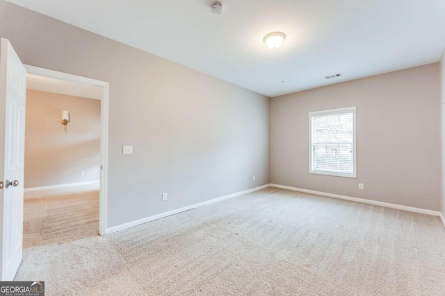 carpeted spare room featuring visible vents and baseboards