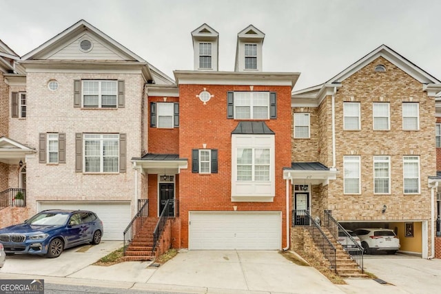 townhome / multi-family property featuring a garage, brick siding, and driveway