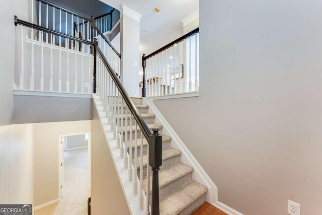 stairway featuring baseboards and a towering ceiling