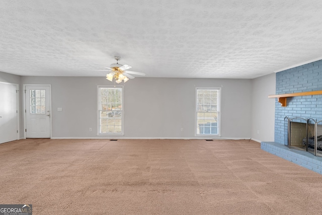 unfurnished living room with a ceiling fan, a fireplace, carpet floors, and a textured ceiling