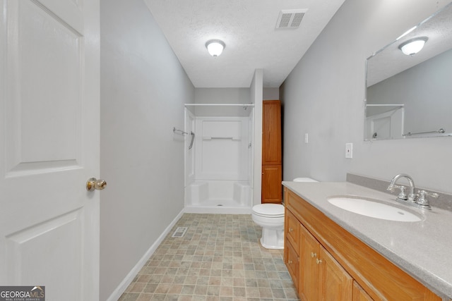 full bath with visible vents, toilet, a stall shower, a textured ceiling, and vanity