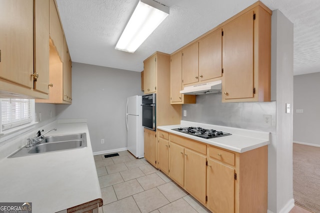 kitchen featuring freestanding refrigerator, a sink, oven, black gas cooktop, and under cabinet range hood