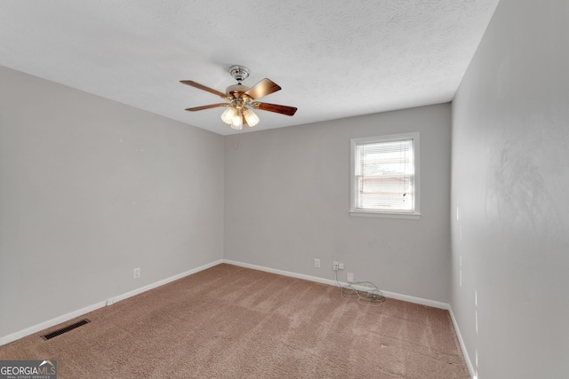 empty room with visible vents, a textured ceiling, baseboards, and carpet floors