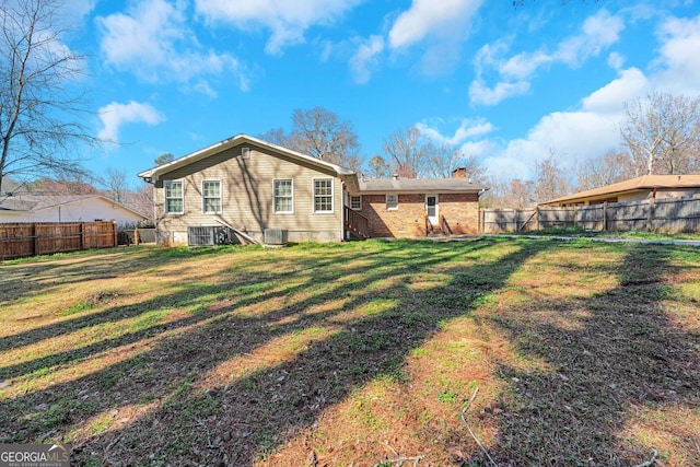 rear view of property with a yard, a fenced backyard, and a chimney