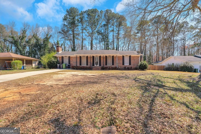 single story home featuring a front lawn, brick siding, a chimney, and fence