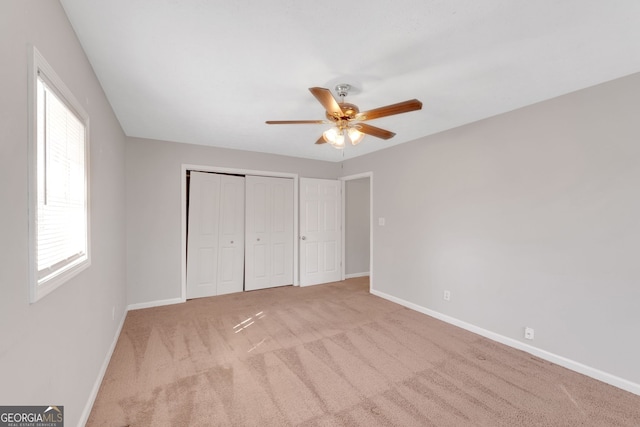 unfurnished bedroom with a closet, baseboards, carpet, and ceiling fan