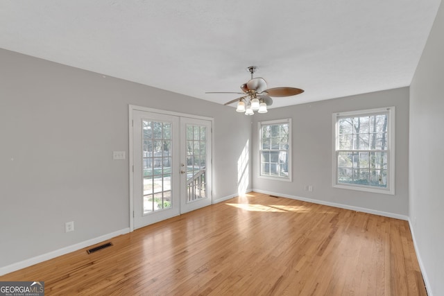 unfurnished room with french doors, baseboards, visible vents, and light wood finished floors