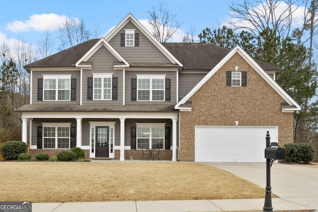 view of front of house with a front yard, a porch, concrete driveway, a garage, and brick siding