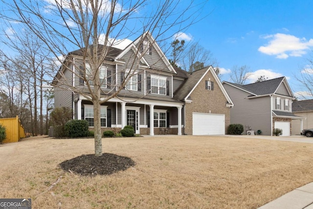 view of front of house featuring a front yard, a porch, a garage, and concrete driveway