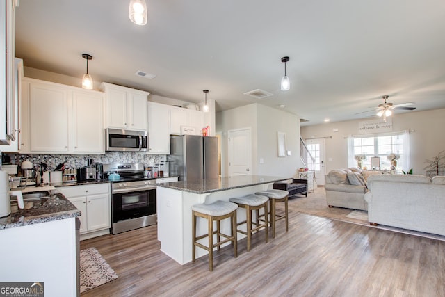 516 Grand Magnolia St, Jackson, GA 30233 - kitchen with stainless steel appliances, open floor plan, a kitchen breakfast bar, a kitchen island, and backsplash