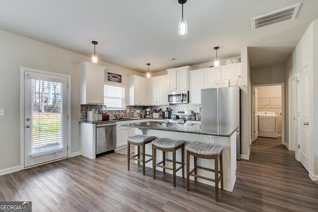 516 Grand Magnolia St, Jackson, GA 30233 - kitchen featuring stainless steel appliances, washer / dryer, dark wood-type flooring, and white cabinetry