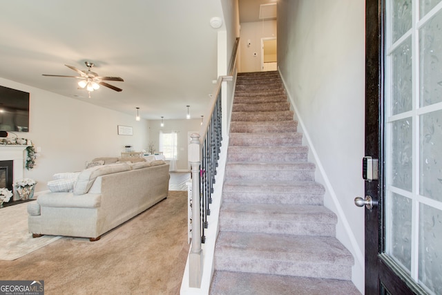 516 Grand Magnolia St, Jackson, GA 30233 - staircase with a ceiling fan, a glass covered fireplace, carpet floors, and baseboards