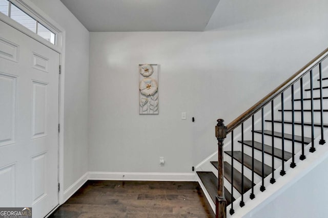 entrance foyer featuring stairway, dark wood-type flooring, and baseboards