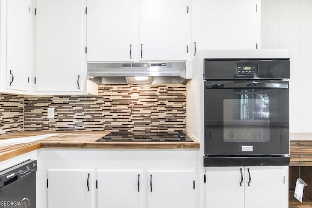 kitchen with black appliances, under cabinet range hood, wood counters, backsplash, and white cabinetry