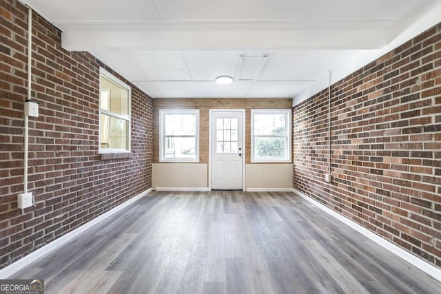 unfurnished sunroom featuring a wealth of natural light and beamed ceiling