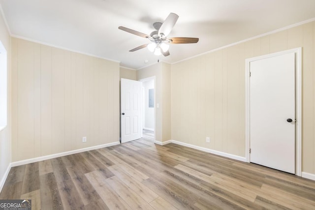 unfurnished bedroom with wood finished floors, baseboards, and ornamental molding